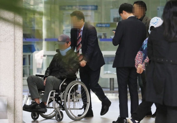 조국 전 법무부장관의 동생 조모씨가 21일 오후 서울중앙지검에 휠체어를 타고 목 보호대를 한 채 출석하고 있다. /연합뉴스