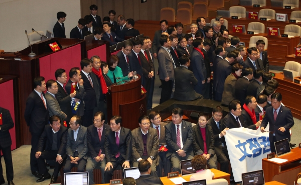 자유한국당 의원들이 30일 오후 국회 본회의장에서 공수처법에 반대하며 의장석을 둘러싸고 있다. /연합뉴스