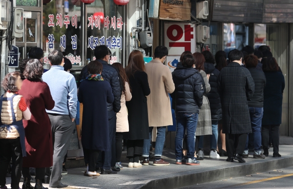 11일 서울 시내 한 약국에서 시민들이 공적 마스크를 구매하기 위해 줄을 서 있다. /연합뉴스