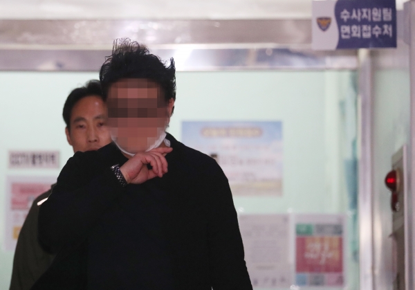 서울 강북구 우이동 아파트 경비원 폭행 가해자로 지목된 주민이 17일 오후 강북경찰서에 출석해 조사를 받은 뒤 18일 0시쯤 귀가하고 있다. /연합뉴스