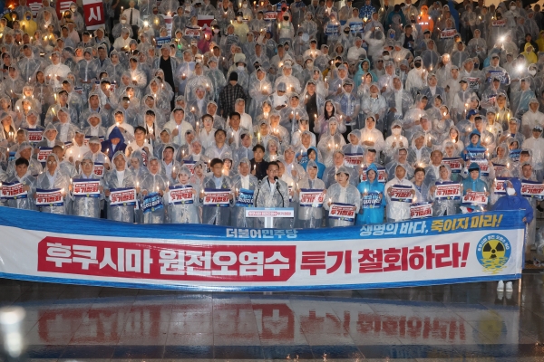 더불어민주당이 23일 국회 본청 앞 계단에서 열린 후쿠시마 원전오염수 해양투기 철회 촉구 촛불집회를 진행하고 있다. (사진=연합뉴스)