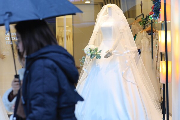 서울 마포구 아현동 웨딩거리의 한 웨딩드레스 판매점 앞을 시민들이 지나가고 있다. (사진=연합뉴스)