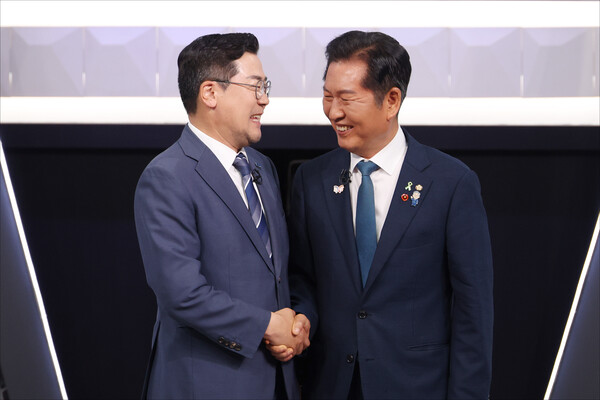 더불어민주당 당대표 선거에 출마한 정청래(오른쪽)·박찬대 후보가 27일 오후 KBS 신관 공개홀에서 2차 TV토론회 시작 전 악수를 하고 있다. /국회사진기자단